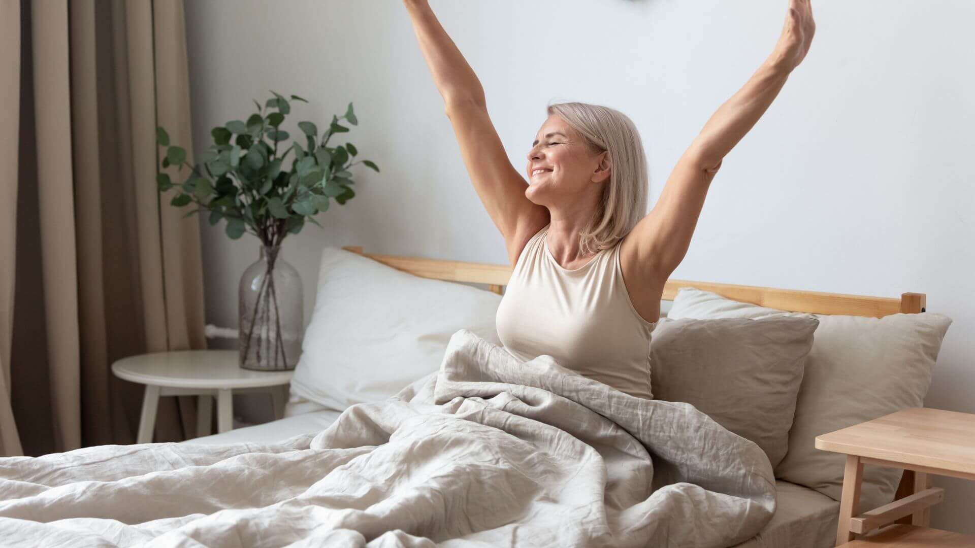 Woman waking up happy in bed