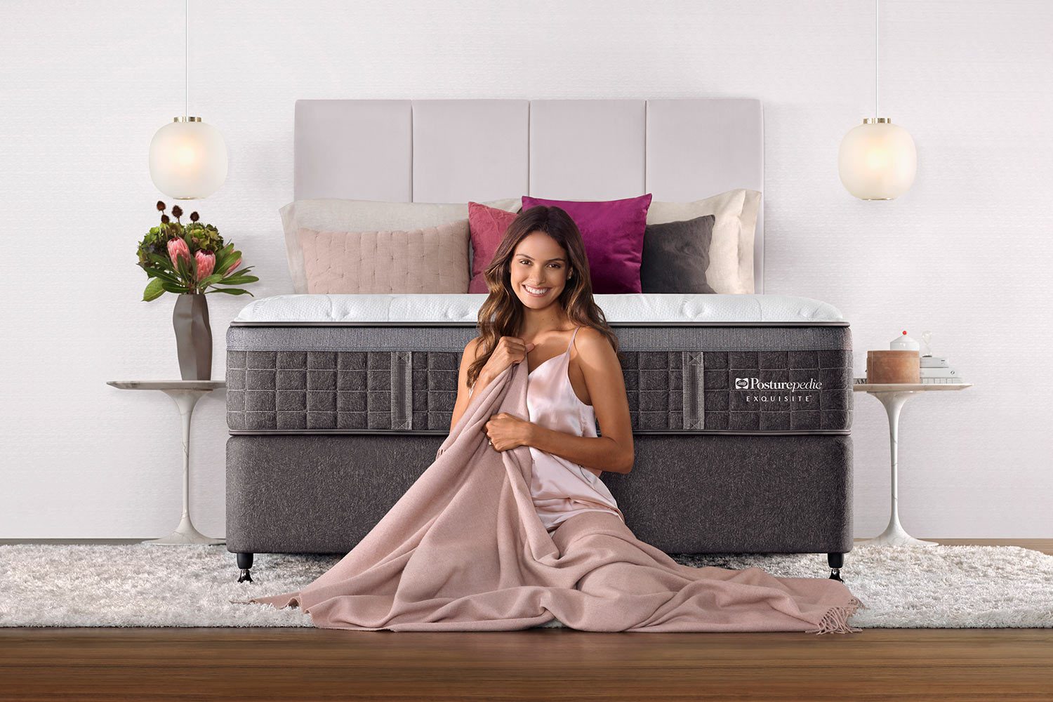 Model sitting in front of Sealy Posturepedic Exquisite mattress
