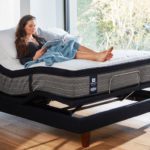 Young woman lies on a Sealy adjustable bed reading a book
