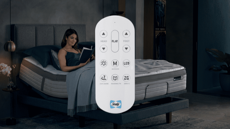 Remote for Sealy adjustable bed base with adjustable bed in background