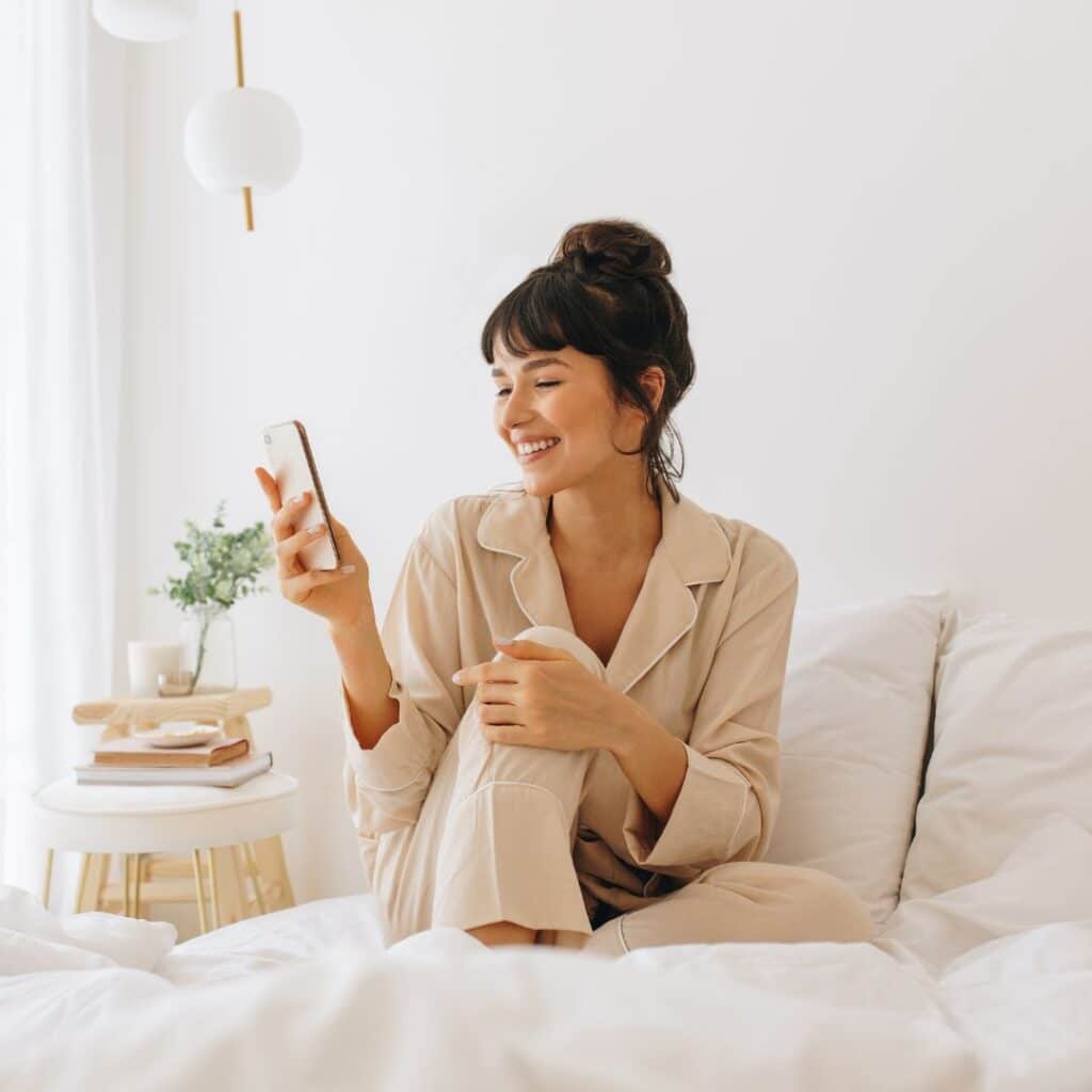 Woman looking at phone in bed