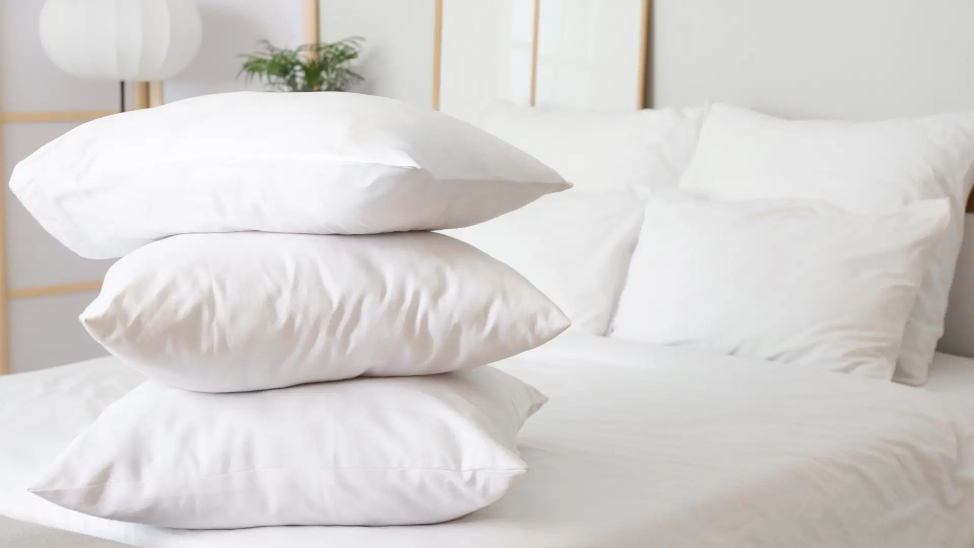 Pile of pillows of different sizes on a bed