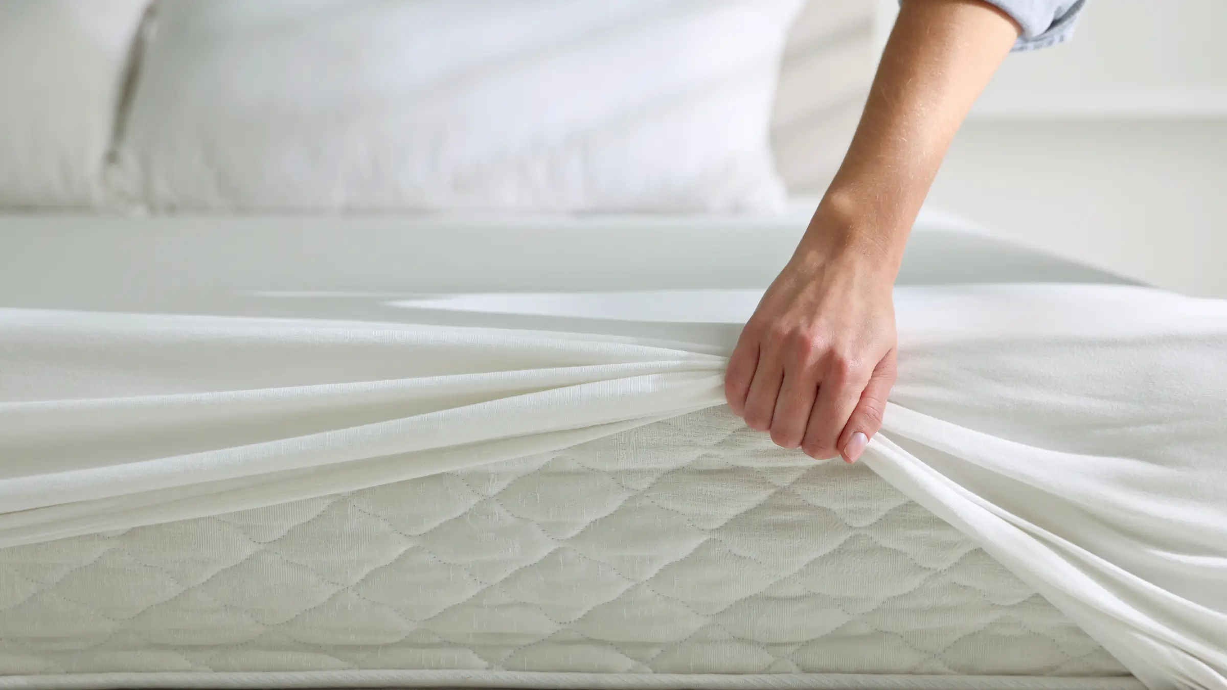 Woman lifting mattress protector